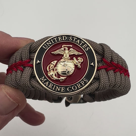 Thick, rigid and comfortable braided United States Marine Corps bracelet featuring a 24K gold plated USMC Eagle Globe and Anchor medallion, a gold Cobra style tactical buckle and woven with tan 550 paracord and Imperial Red micro cord.