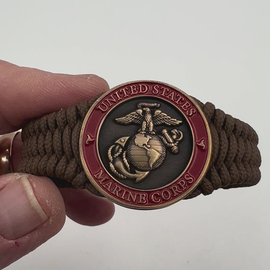 Thin, narrow, flexible and comfortable braided United States Marine Corps bracelet featuring a 24K antique gold plated USMC Eagle Globe and Anchor medallion, a gold Cobra style tactical buckle and woven with Coyote Brown Type-1 paracord.