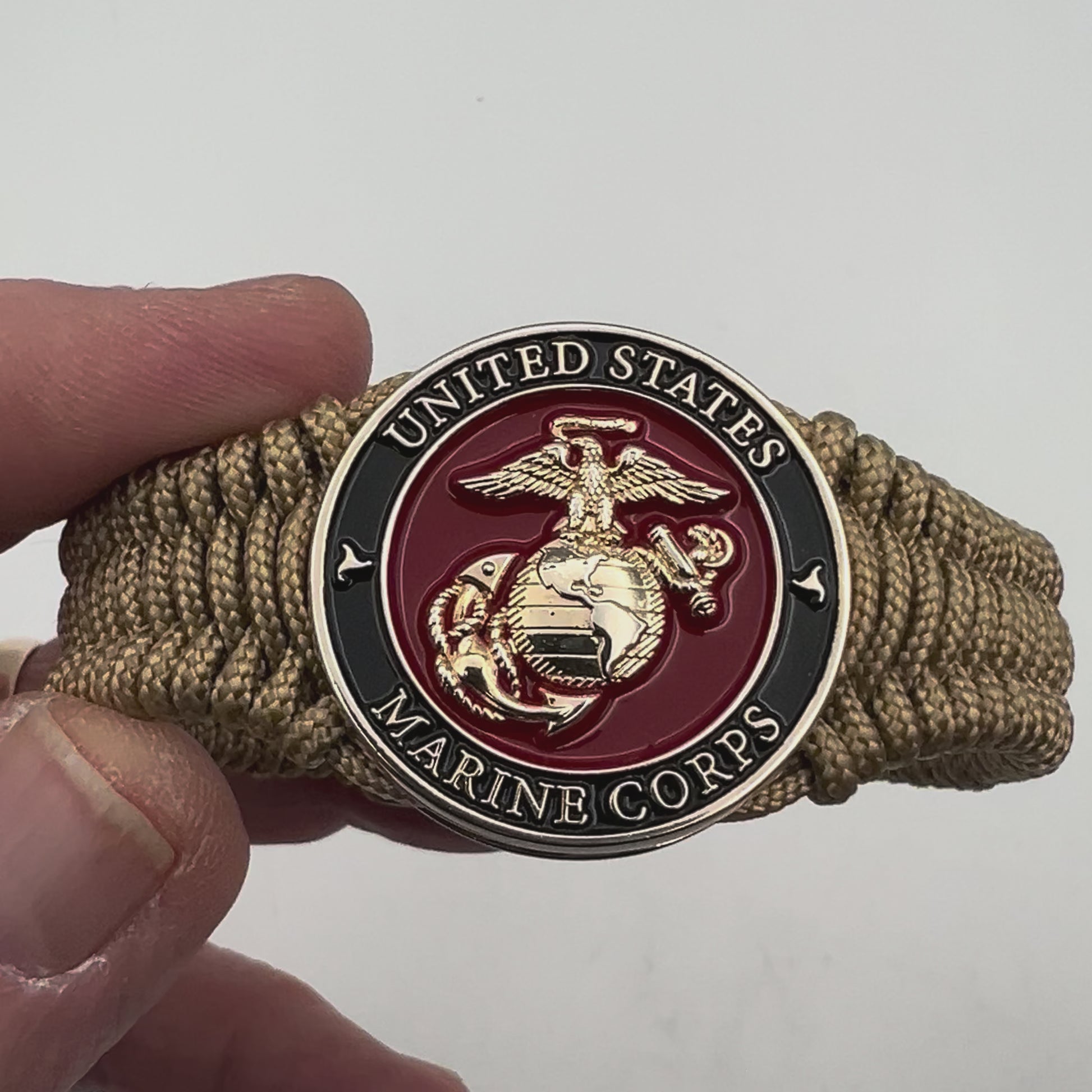 Thick, narrow, flexible and comfortable braided United States Marine Corps bracelet featuring a 24K gold plated USMC officer Eagle Globe and Anchor medallion, a gold Cobra style tactical buckle and woven with gold Type-1 paracord.