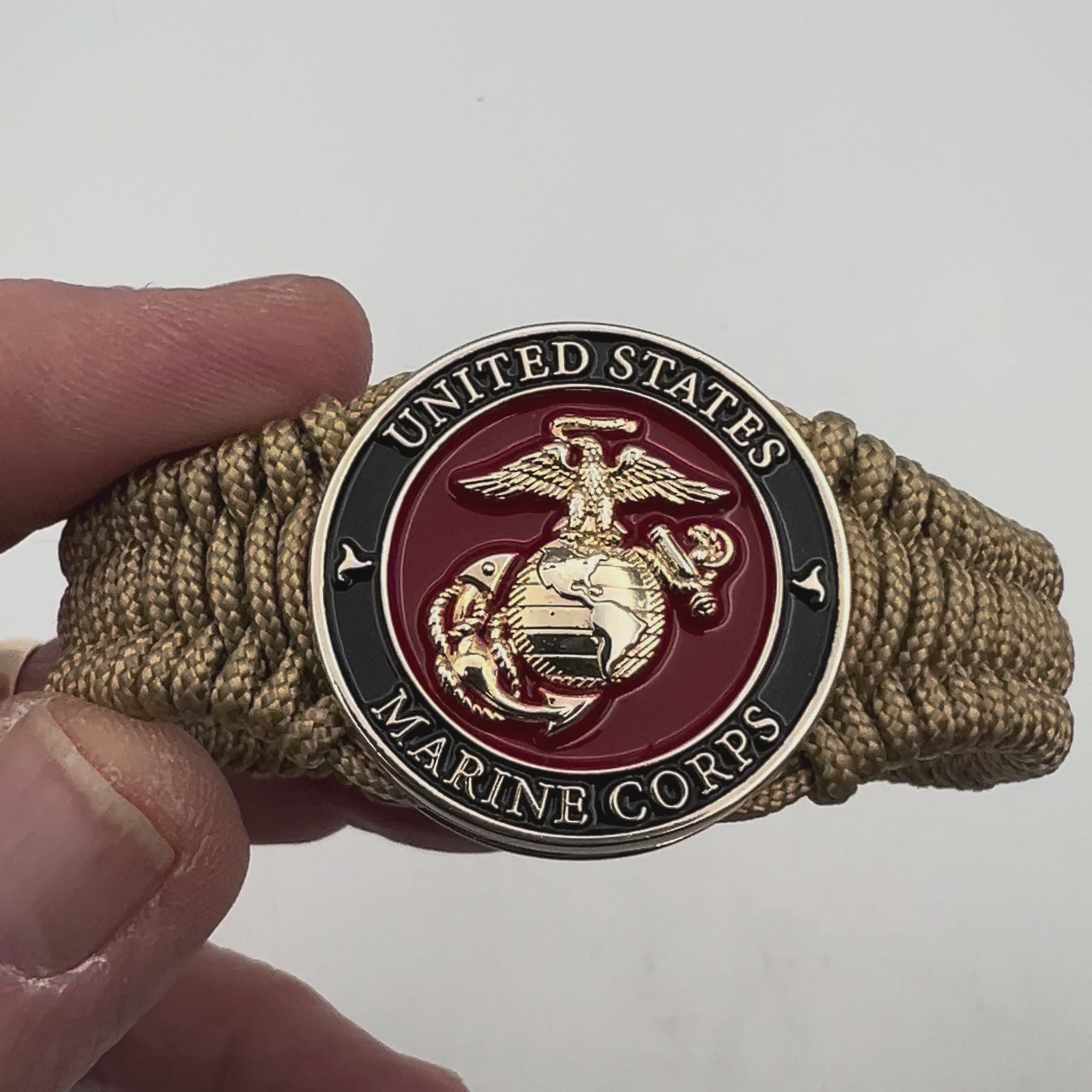 Thick, narrow, flexible and comfortable braided United States Marine Corps bracelet featuring a 24K gold plated USMC officer Eagle Globe and Anchor medallion, a gold Cobra style tactical buckle and woven with gold Type-1 paracord.