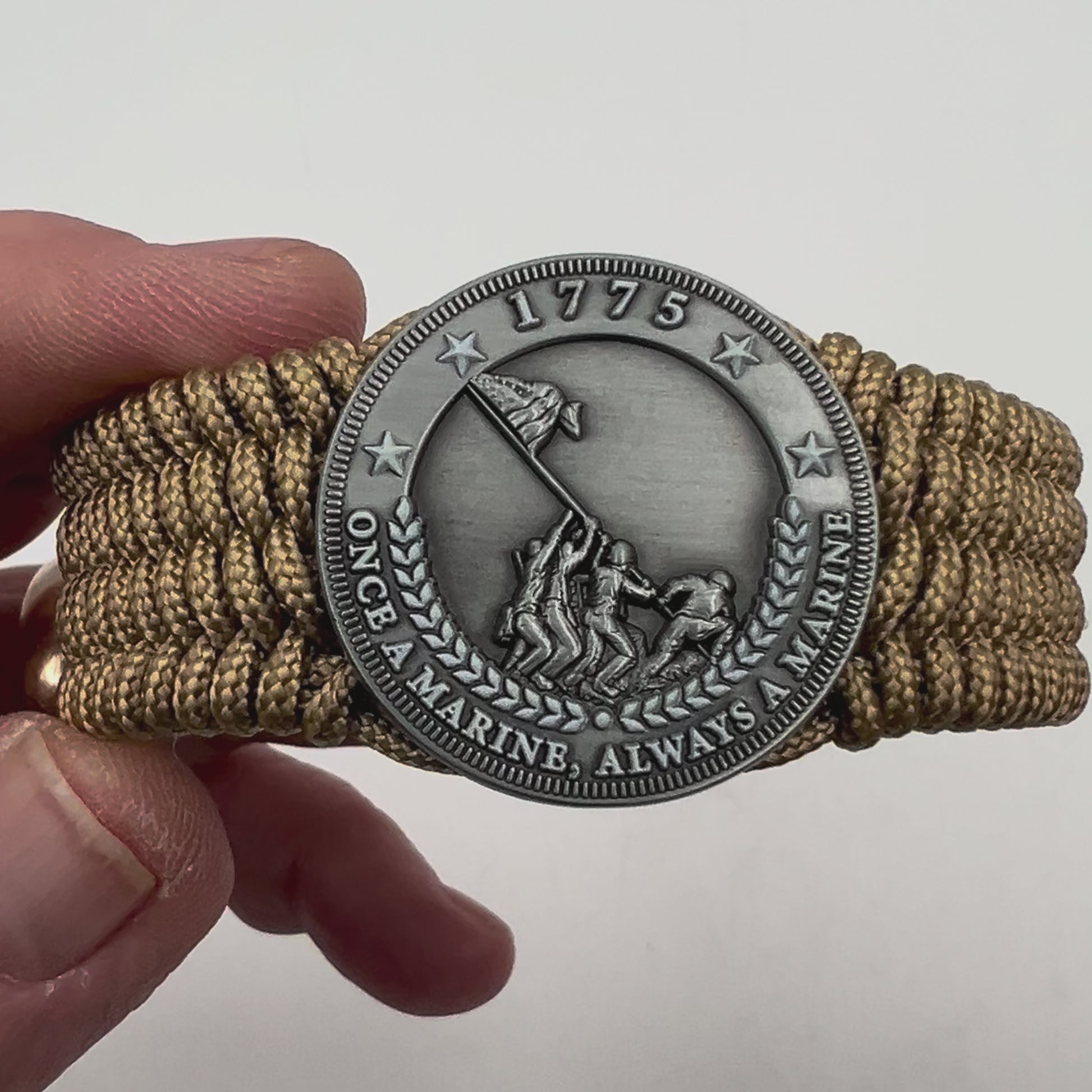 Thin, wide, flexible and comfortable braided United States Marine Corps Iwo Jima bracelet featuring an antique silver plated Iwo Jima flag raising medallion, a gold Cobra style tactical buckle and woven with gold Type-1 paracord.