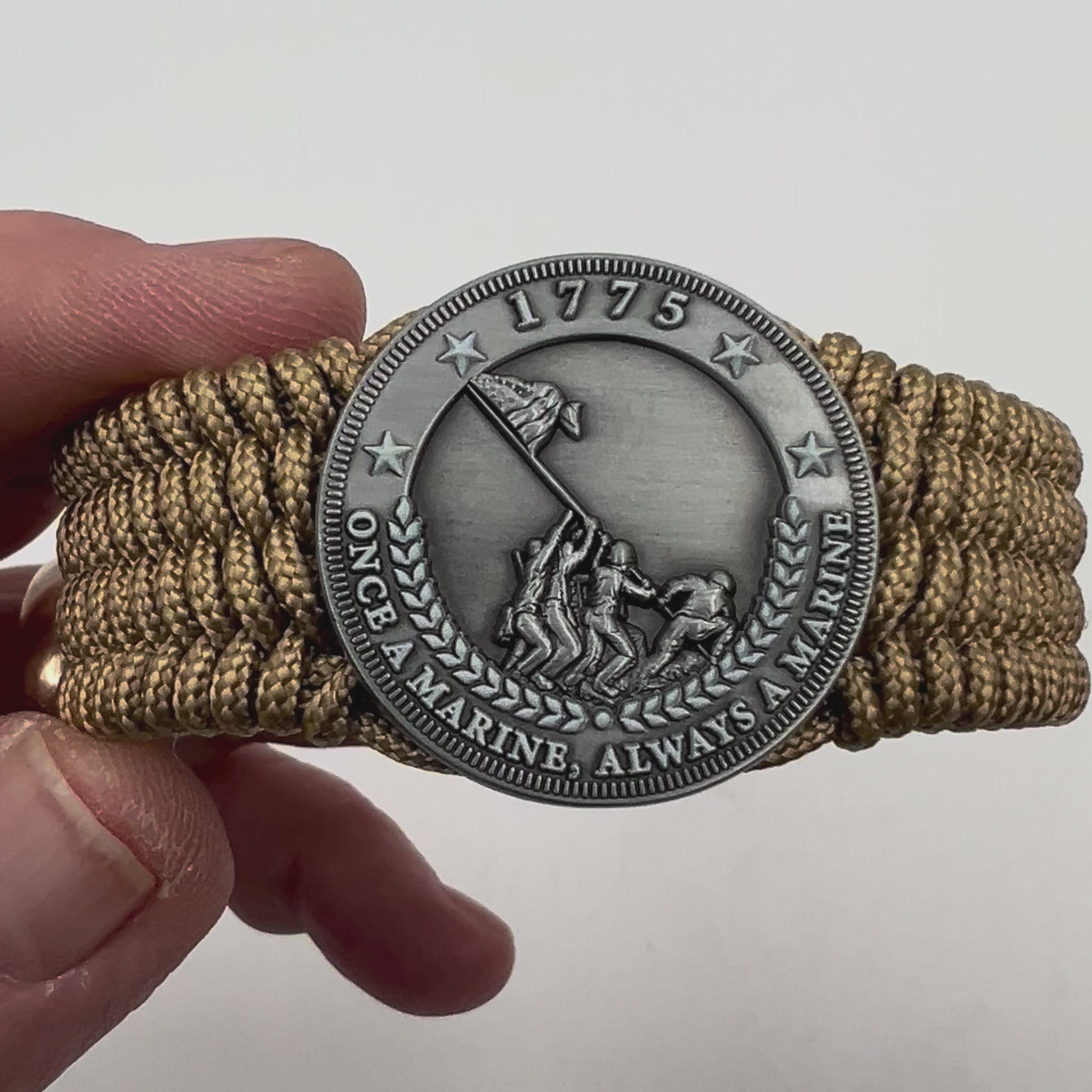 Thin, wide, flexible and comfortable braided United States Marine Corps Iwo Jima bracelet featuring an antique silver plated Iwo Jima flag raising medallion, a gold Cobra style tactical buckle and woven with gold Type-1 paracord.