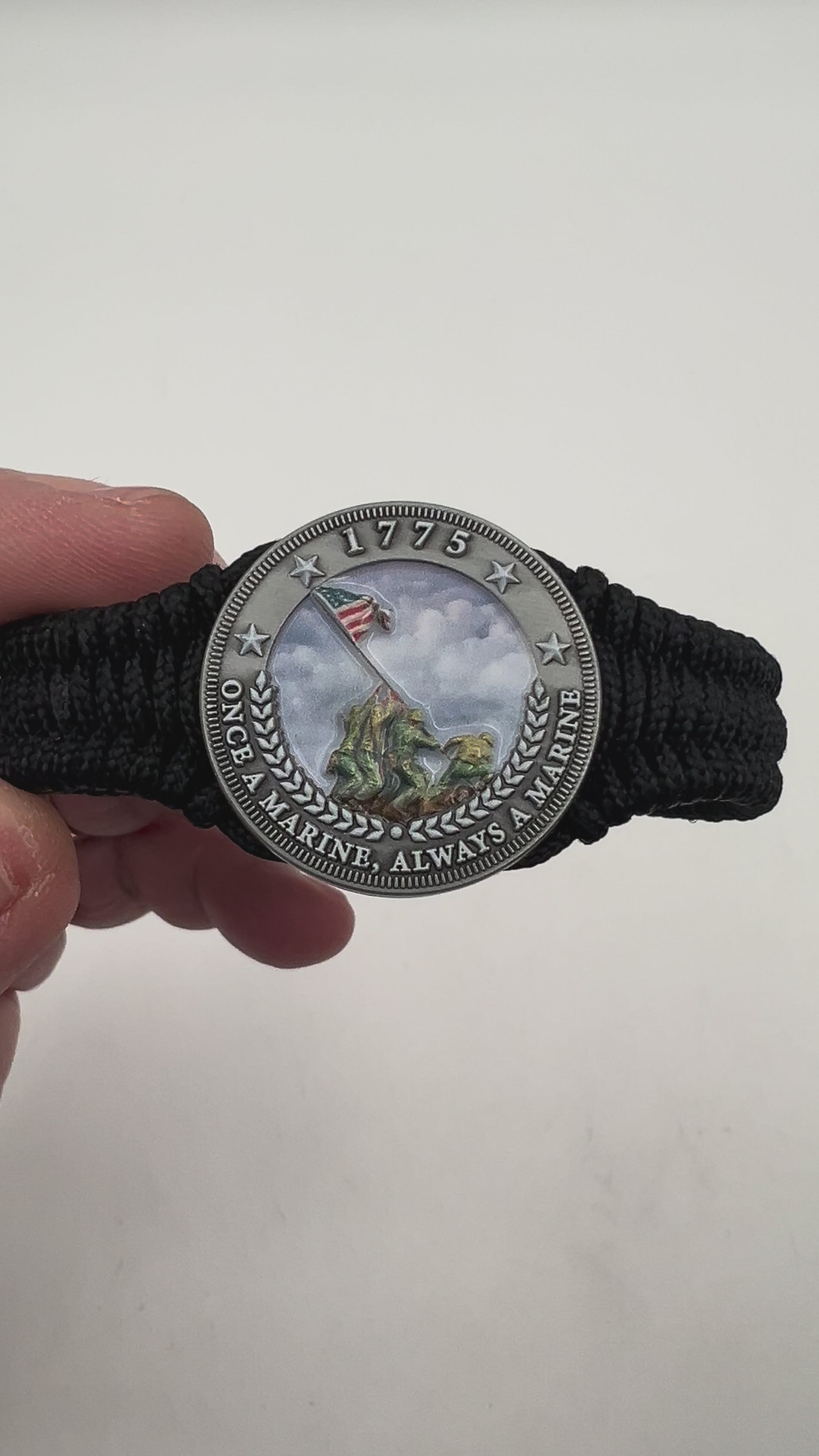 Thin, narrow and comfortable braided United States Marine Corps Iwo Jima bracelet featuring an antique silver plated UV painted Iwo Jima flag raising medallion, a black Cobra style tactical buckle and woven with black type-1 paracord.