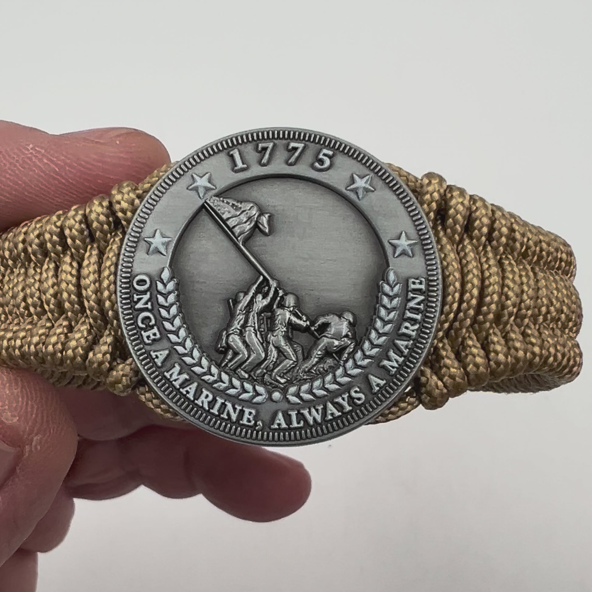 Thin, narrow, flexible and comfortable braided United States Marine Corps Iwo Jima bracelet featuring an antique silver plated Iwo Jima flag raising medallion, a gold Cobra style tactical buckle and woven with gold type-1 paracord.