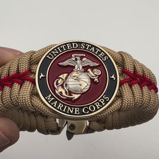 Thick and comfortable braided United States Marine Corps bracelet featuring a 24K gold and silver plated USMC officer Eagle Globe and Anchor medallion, a Cobra style tactical buckle and woven with gold 550 and Imperial red micro paracord.