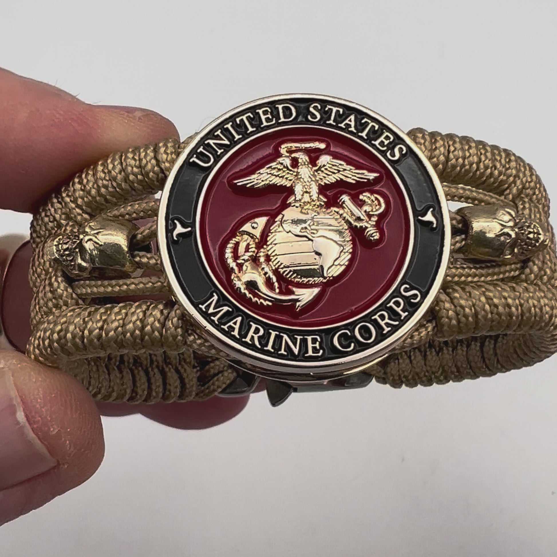 Thin, medium width, flexible and comfortable braided United States Marine Corps bracelet featuring a 24K gold plated USMC officer Eagle Globe and Anchor medallion, two gold plated skulls, a gold Cobra style tactical buckle and woven with gold Type-1 paracord.