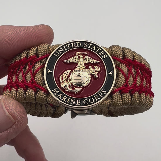 Thick, wide, rigid and comfortable braided United States Marine Corps bracelet featuring a 24K gold plated USMC Eagle Globe and Anchor medallion, a gold Cobra style tactical buckle and woven with gold 550 paracord and Imperial Red nano and micro cord.