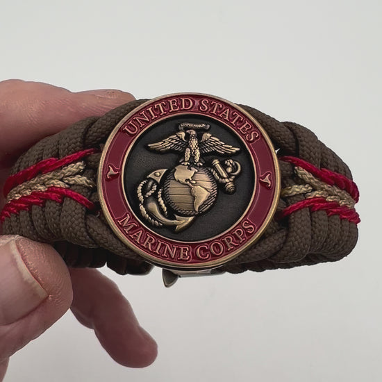 Thick, medium width, rigid and comfortable braided United States Marine Corps bracelet featuring a 24K antique gold plated USMC Eagle Globe and Anchor medallion, a gold Cobra style tactical buckle and woven with Coyote Brown 550 paracord and Imperial Red and Gold micro cord.
