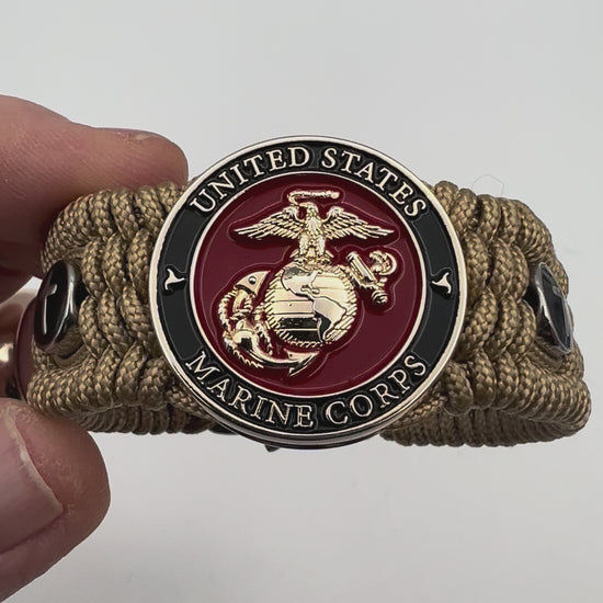 Thin, medium width, flexible and comfortable braided United States Marine Corps bracelet featuring a 24K gold plated USMC officer Eagle Globe and Anchor medallion, two Christian crosses, a gold Cobra style tactical buckle and woven with gold Type-1 paracord.