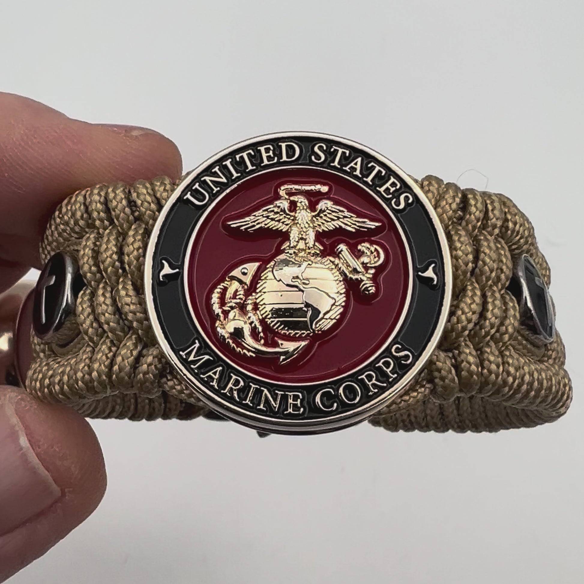 Thin, medium width, flexible and comfortable braided United States Marine Corps bracelet featuring a 24K gold plated USMC officer Eagle Globe and Anchor medallion, two Christian crosses, a gold Cobra style tactical buckle and woven with gold Type-1 paracord.