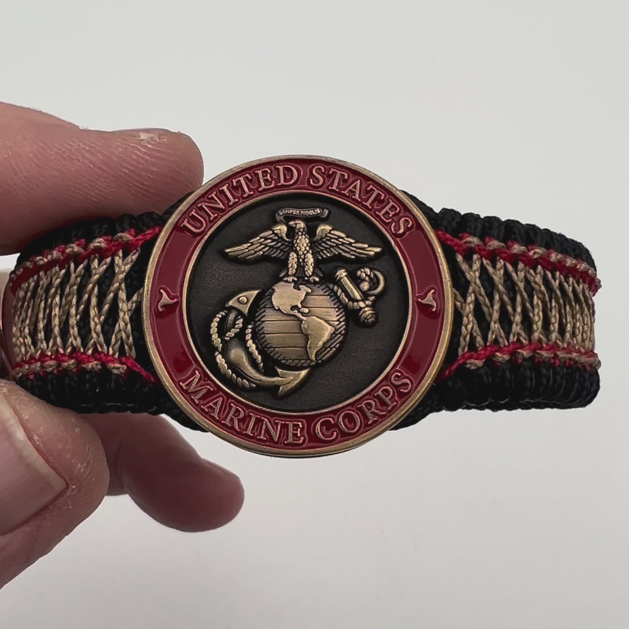 Thin, medium width, flexible and comfortable braided United States Marine Corps bracelet featuring a 24K antique gold plated USMC Eagle Globe and Anchor medallion, a black Cobra style tactical buckle and woven with black Type-1 paracord and Imperial Red and Gold nano cord.