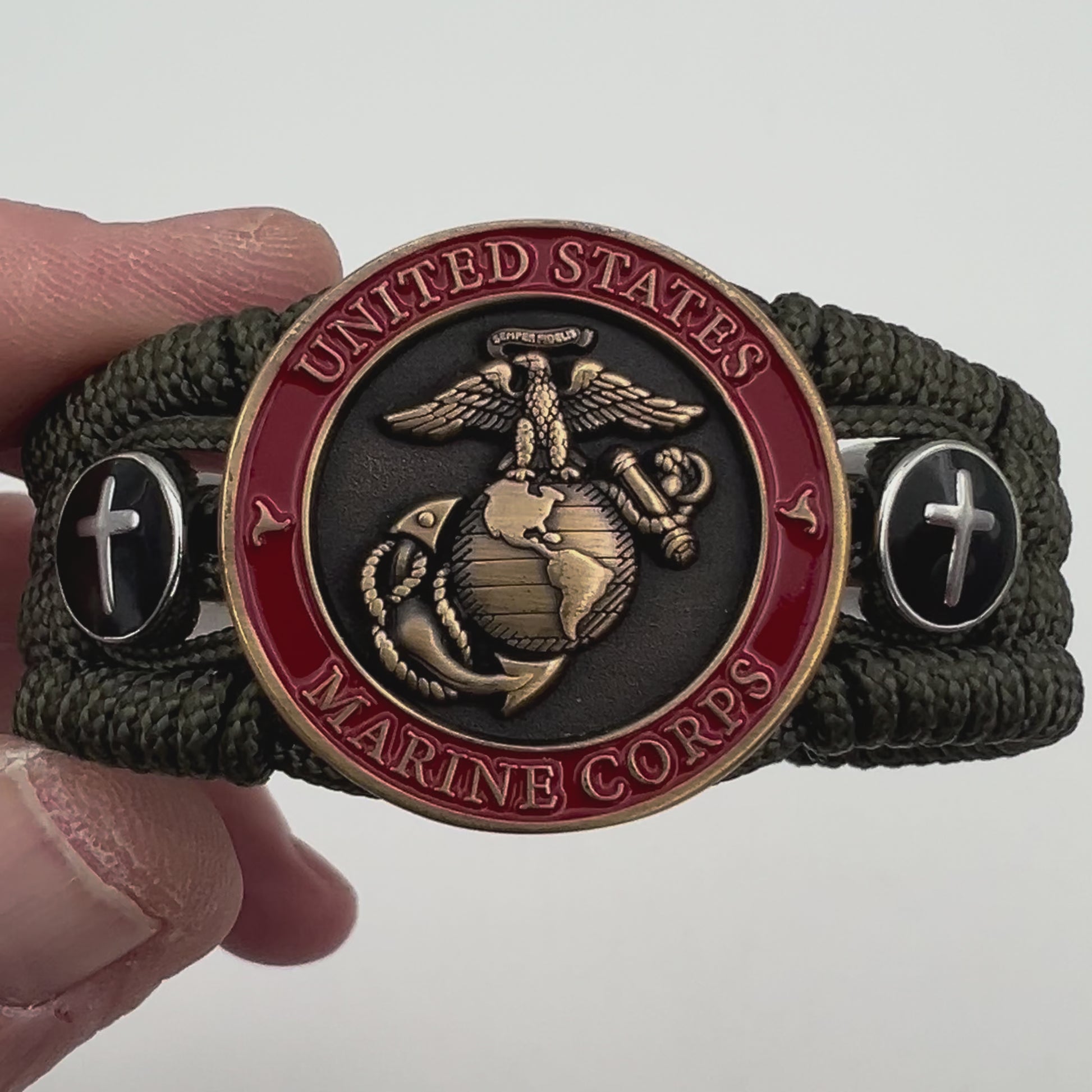 Thin, medium width, flexible and comfortable braided United States Marine Corps bracelet featuring a 24K antique gold plated USMC officer Eagle Globe and Anchor medallion, two Christian crosses, a black Cobra style tactical buckle and woven with Olive Drab Type-1 paracord.