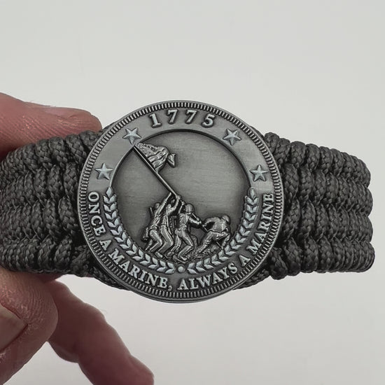 Thin, wide, flexible and comfortable braided United States Marine Corps Iwo Jima bracelet featuring an antique silver plated Iwo Jima flag raising medallion, a silver Cobra style tactical buckle and woven with gray Type-1 paracord.