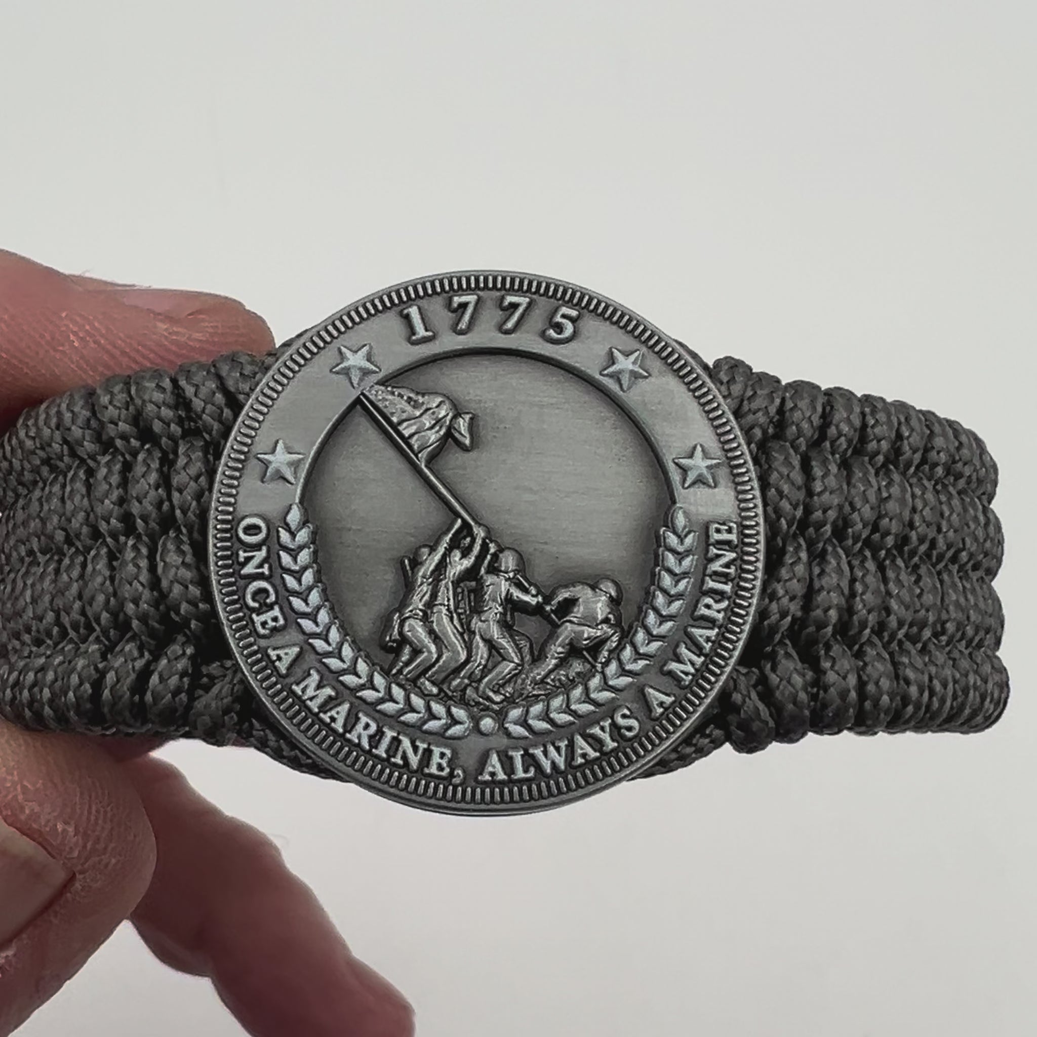 Thin, wide, flexible and comfortable braided United States Marine Corps Iwo Jima bracelet featuring an antique silver plated Iwo Jima flag raising medallion, a silver Cobra style tactical buckle and woven with gray Type-1 paracord.