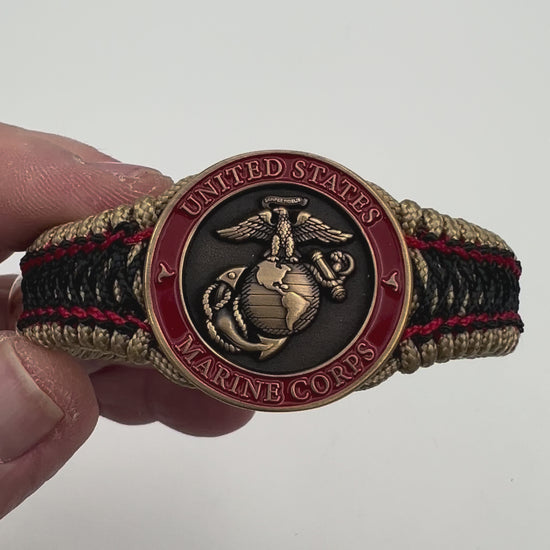 Thin, narrow, very thin and flexible and comfortable braided United States Marine Corps bracelet featuring a 24K antique gold plated USMC Eagle Globe and Anchor medallion, a gold Cobra style tactical buckle and woven with gold Type-1 paracord and Imperial Red and Black nano cord.