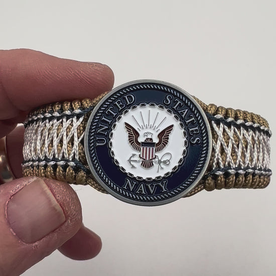 Thin, wide and comfortable braided United States Navy bracelet featuring an antique silver plated Navy medallion, a gold Cobra style tactical buckle and woven with gold Type-1 paracord and Navy Blue and White nano cord.
