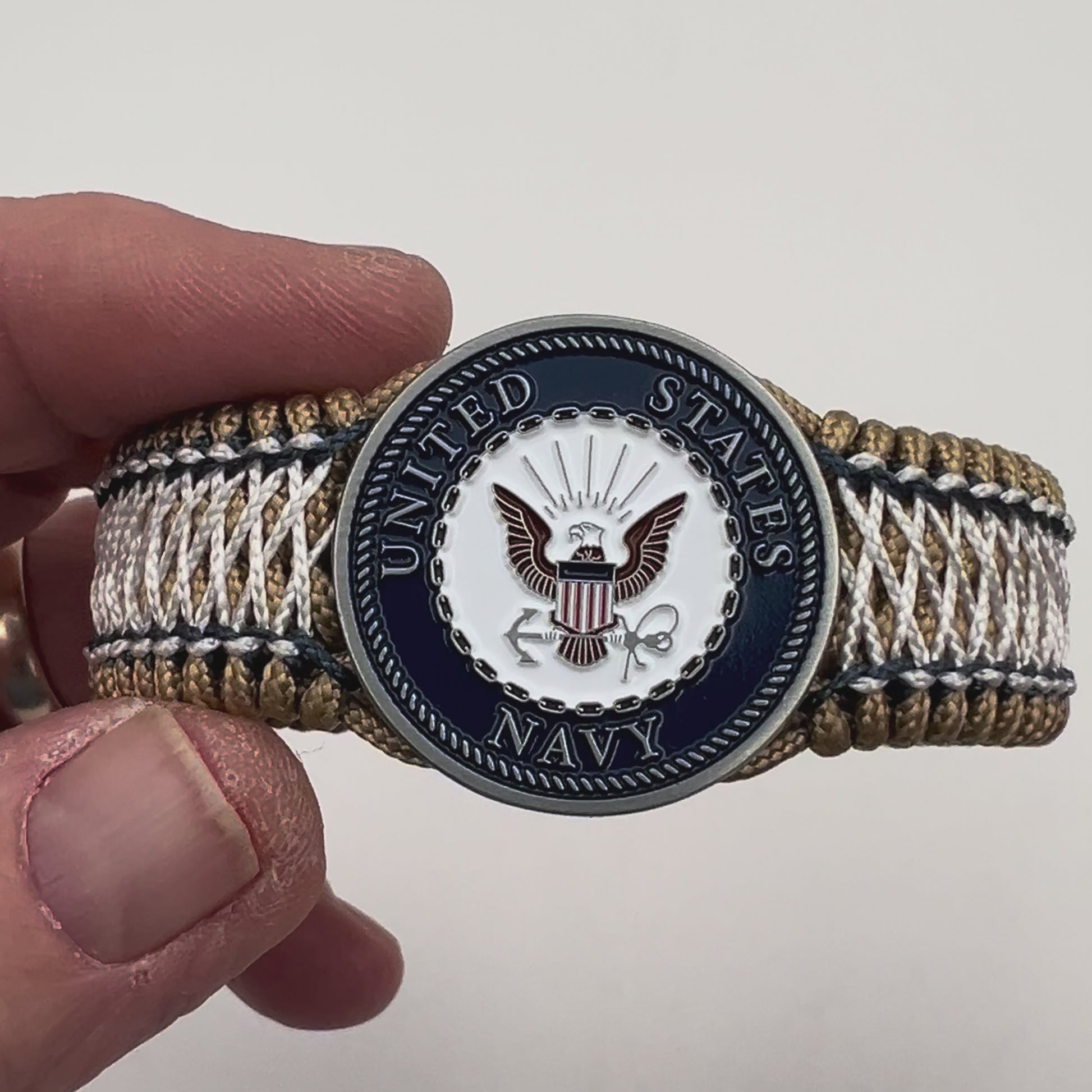 Thin, wide and comfortable braided United States Navy bracelet featuring an antique silver plated Navy medallion, a gold Cobra style tactical buckle and woven with gold Type-1 paracord and Navy Blue and White nano cord.