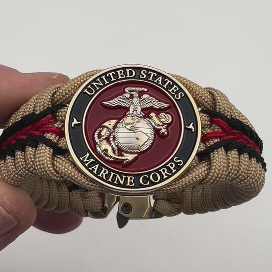 Thick and comfortable braided United States Marine Corps bracelet featuring a 24K gold and silver plated USMC officer Eagle Globe and Anchor medallion, a Cobra style tactical buckle and woven with gold 550 and Imperial red micro paracord.