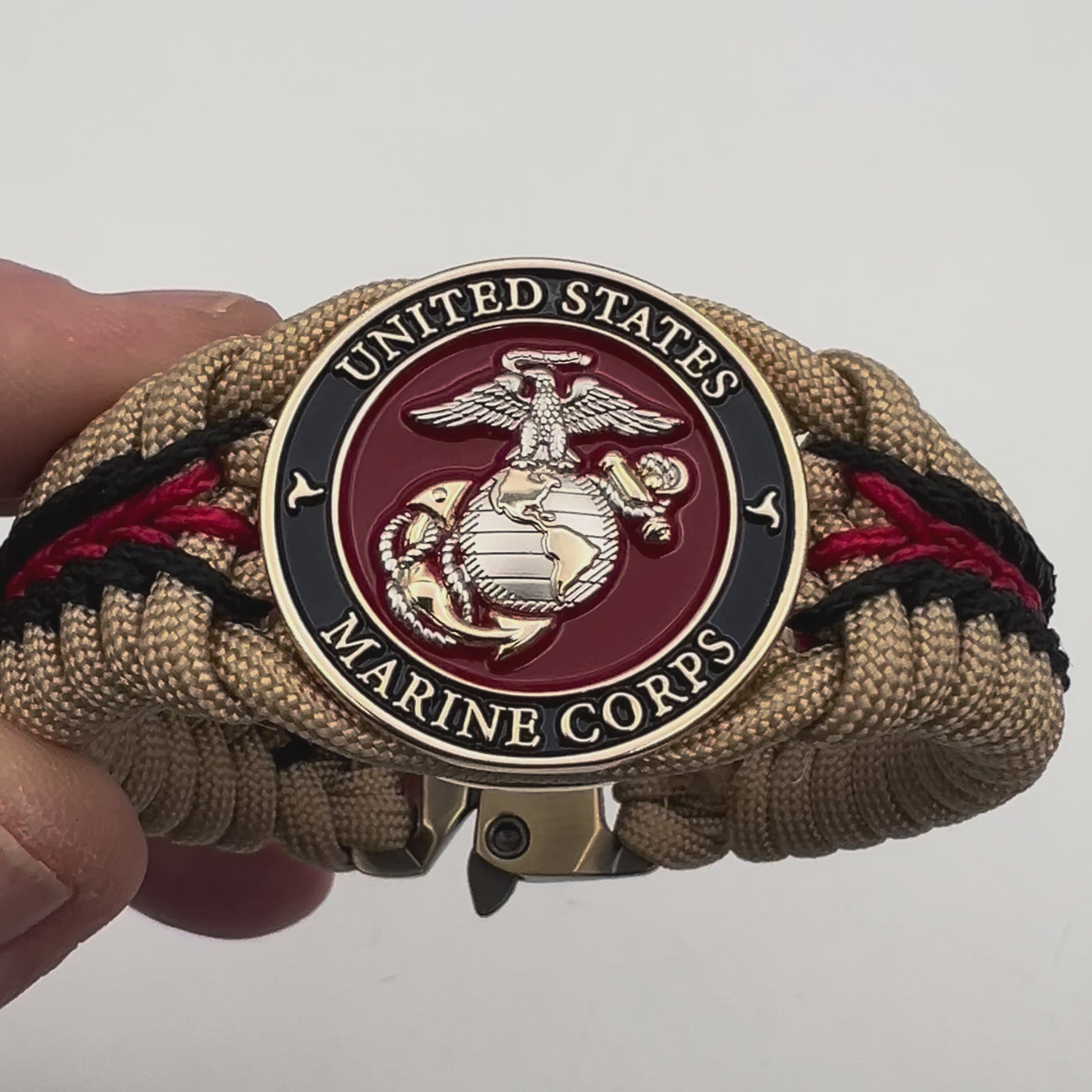 Thick and comfortable braided United States Marine Corps bracelet featuring a 24K gold and silver plated USMC officer Eagle Globe and Anchor medallion, a Cobra style tactical buckle and woven with gold 550 and Imperial red micro paracord.