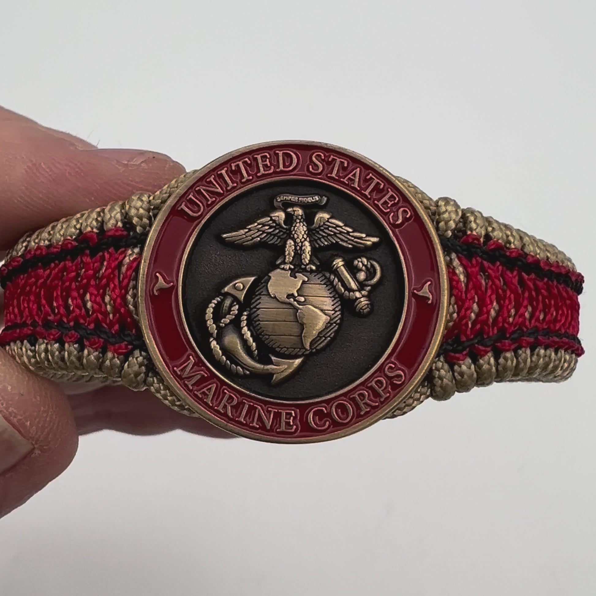 Thin, narrow, very thin and flexible and comfortable braided United States Marine Corps bracelet featuring a 24K antique gold plated USMC Eagle Globe and Anchor medallion, a gold Cobra style tactical buckle and woven with gold Type-1 paracord and Imperial Red and Black nano cord.