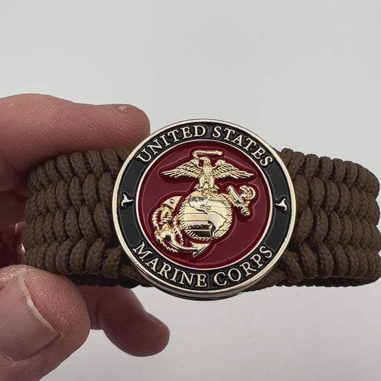 Thin, medium width, flexible and comfortable braided United States Marine Corps bracelet featuring a 24K gold plated USMC officer Eagle Globe and Anchor medallion, a gold Cobra style tactical buckle and woven with Coyote Brown Type-1 paracord.