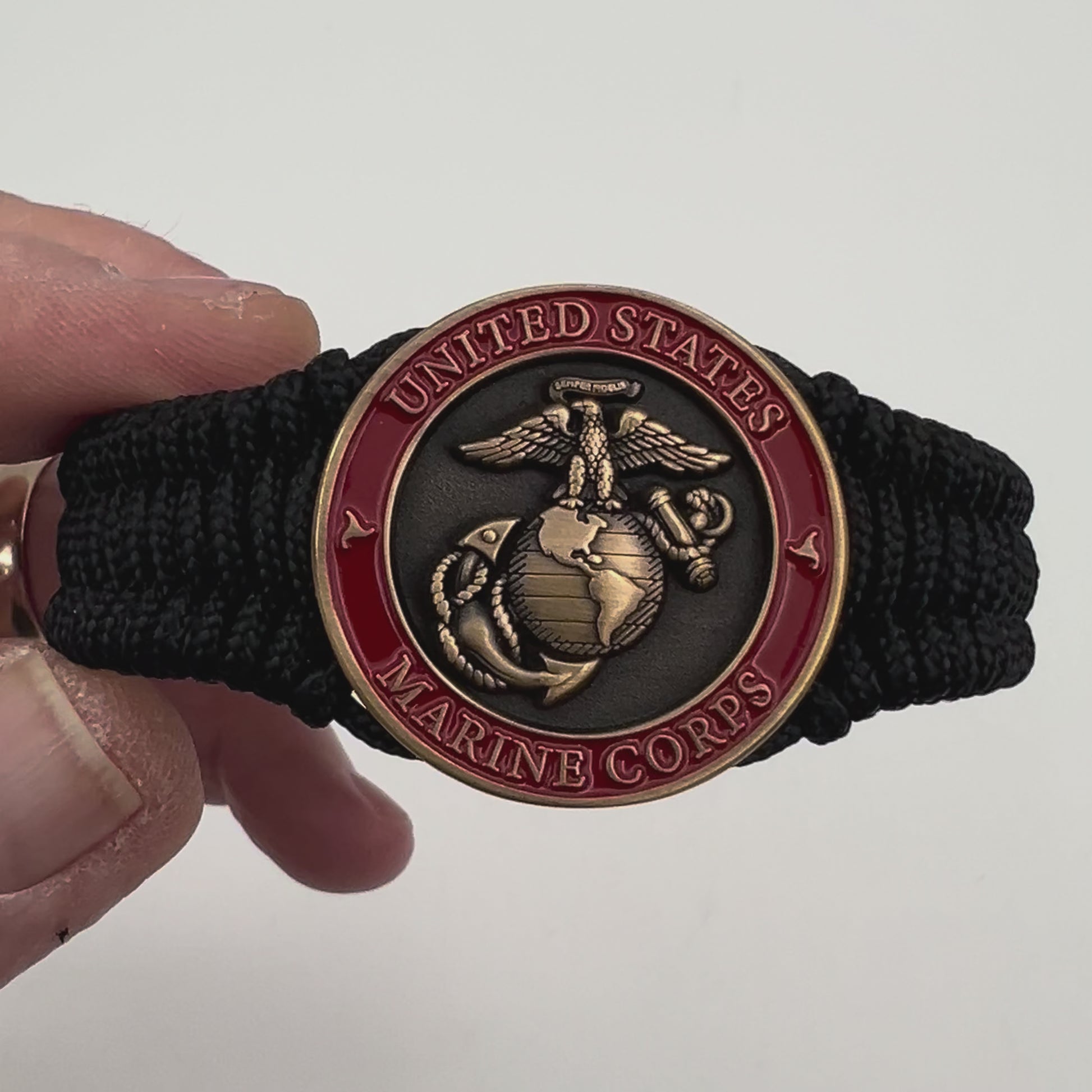 Thin, narrow, flexible and comfortable braided United States Marine Corps bracelet featuring a 24K antique gold plated USMC Eagle Globe and Anchor medallion, a black Cobra style tactical buckle and woven with black Type-1 paracord.