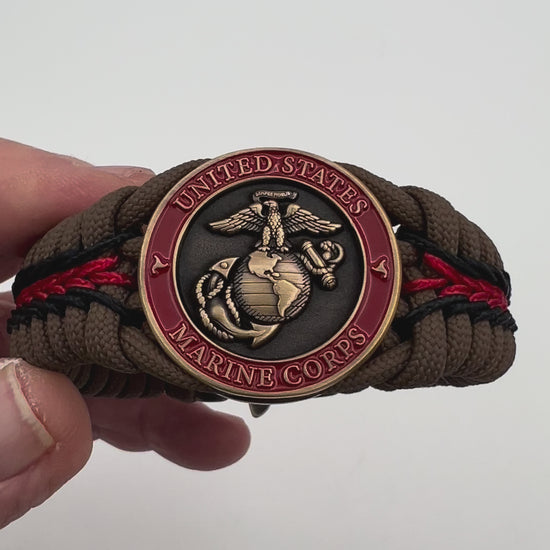 Thick, medium width, rigid and comfortable braided United States Marine Corps bracelet featuring a 24K antique gold plated USMC Eagle Globe and Anchor medallion, a gold Cobra style tactical buckle and woven with Coyote Brown 550 paracord and Imperial Red and Black micro cord.